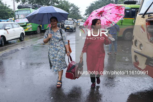 Women hold umbrellas as they walk in the monsoon rain in Kolkata, India, on September 26, 2024. 