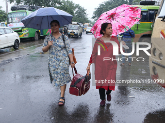 Women hold umbrellas as they walk in the monsoon rain in Kolkata, India, on September 26, 2024. (