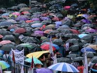 Citizens hold umbrellas and attend a protest rally against the rape and murder of a PGT woman doctor at the government-run R G Kar Medical C...