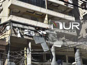 People and rescuers gather at the site of an Israeli airstrike that targets an apartment on al-Qaem Street in Beirut's southern suburbs on S...