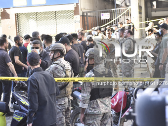 People and rescuers gather at the site of an Israeli airstrike that targets an apartment on al-Qaem Street in Beirut's southern suburbs on S...