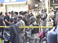 People and rescuers gather at the site of an Israeli airstrike that targets an apartment on al-Qaem Street in Beirut's southern suburbs on S...