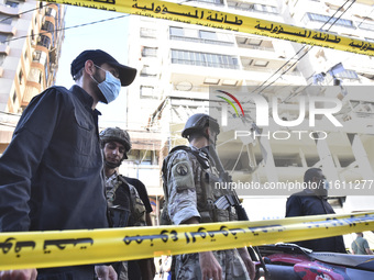 People and rescuers gather at the site of an Israeli airstrike that targets an apartment on al-Qaem Street in Beirut's southern suburbs on S...