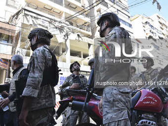 People and rescuers gather at the site of an Israeli airstrike that targets an apartment on al-Qaem Street in Beirut's southern suburbs on S...