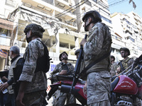 People and rescuers gather at the site of an Israeli airstrike that targets an apartment on al-Qaem Street in Beirut's southern suburbs on S...