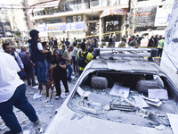 People and rescuers gather at the site of an Israeli airstrike that targets an apartment on al-Qaem Street in Beirut's southern suburbs on S...