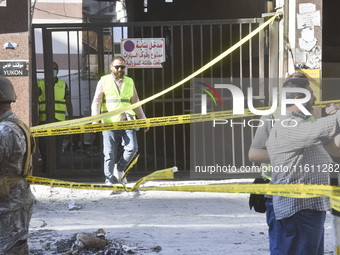 People and rescuers gather at the site of an Israeli airstrike that targets an apartment on al-Qaem Street in Beirut's southern suburbs on S...