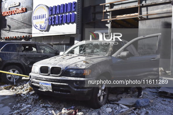 People and rescuers gather at the site of an Israeli airstrike that targets an apartment on al-Qaem Street in Beirut's southern suburbs on S...