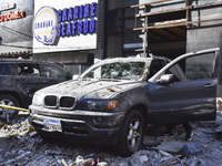 People and rescuers gather at the site of an Israeli airstrike that targets an apartment on al-Qaem Street in Beirut's southern suburbs on S...