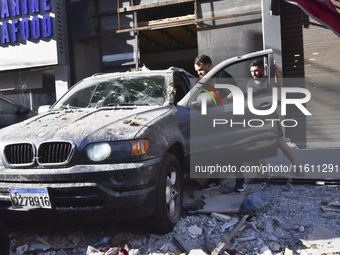 People and rescuers gather at the site of an Israeli airstrike that targets an apartment on al-Qaem Street in Beirut's southern suburbs on S...