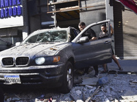 People and rescuers gather at the site of an Israeli airstrike that targets an apartment on al-Qaem Street in Beirut's southern suburbs on S...