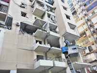 People and rescuers gather at the site of an Israeli airstrike that targets an apartment on al-Qaem Street in Beirut's southern suburbs on S...