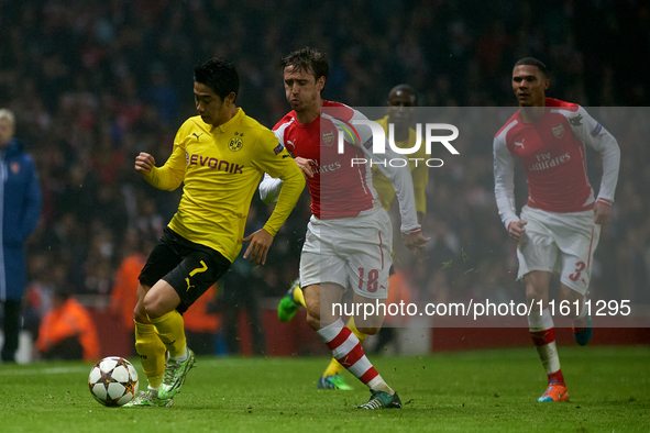 Shinji Kagawa of Borussia Dortmund is closely followed by Nacho Monreal of Arsenal during the UEFA Champions League Group D soccer match bet...