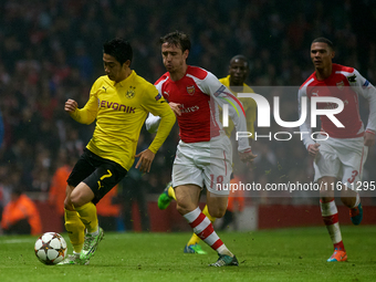 Shinji Kagawa of Borussia Dortmund is closely followed by Nacho Monreal of Arsenal during the UEFA Champions League Group D soccer match bet...