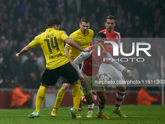 Alexis Sanchez (R) of Arsenal competes for the ball with Milos Jojic (L) of Borussia Dortmund during the UEFA Champions League Group D socce...