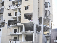 People and rescuers gather at the site of an Israeli airstrike that targets an apartment on al-Qaem Street in Beirut's southern suburbs on S...