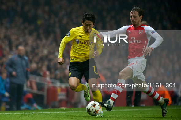 Shinji Kagawa of Borussia Dortmund is closely followed by Nacho Monreal of Arsenal during the UEFA Champions League Group D soccer match bet...