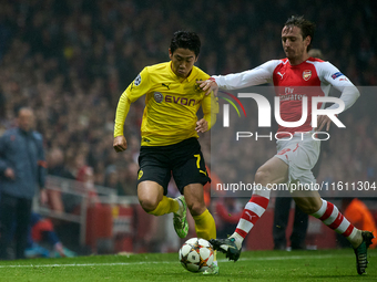 Shinji Kagawa of Borussia Dortmund is closely followed by Nacho Monreal of Arsenal during the UEFA Champions League Group D soccer match bet...