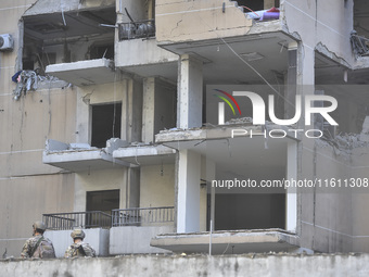 People and rescuers gather at the site of an Israeli airstrike that targets an apartment on al-Qaem Street in Beirut's southern suburbs on S...