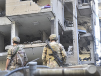 People and rescuers gather at the site of an Israeli airstrike that targets an apartment on al-Qaem Street in Beirut's southern suburbs on S...