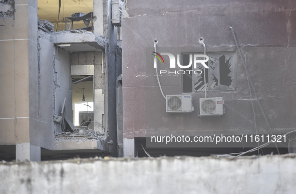 People and rescuers gather at the site of an Israeli airstrike that targets an apartment on al-Qaem Street in Beirut's southern suburbs on S...