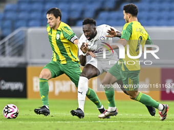 Lucas Mendes (L) of Al Wakrah SC battles for the ball with Yohan Boli (C) of Al-Khor SC during the Ooredoo Qatar Stars League 24/25 match be...