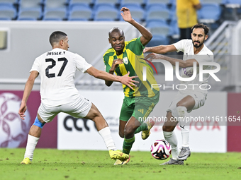 Abdelkarim Hassan (C) of Al Wakrah SC battles for the ball with Gaser Yahia Madani (L) of Al-Khor SC during the Ooredoo Qatar Stars League 2...