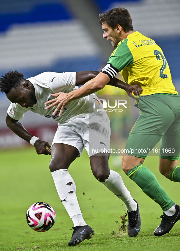 Lucas Mendes (#2) of Al Wakrah SC battles for the ball with Yohan Boli (L) of Al-Khor SC during the Ooredoo Qatar Stars League 24/25 match b...