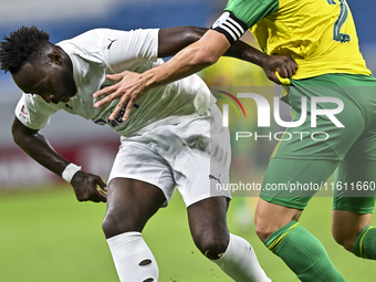 Lucas Mendes (#2) of Al Wakrah SC battles for the ball with Yohan Boli (L) of Al-Khor SC during the Ooredoo Qatar Stars League 24/25 match b...