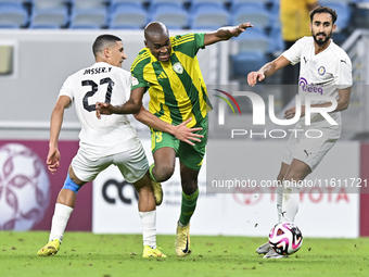 Abdelkarim Hassan (C) of Al Wakrah SC battles for the ball with Gaser Yahia Madani (L) of Al-Khor SC during the Ooredoo Qatar Stars League 2...