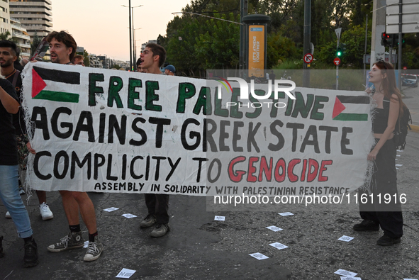 Demonstrators hold a banner outside the Israeli Embassy protesting against the Israeli strikes in Lebanon and the ongoing war in Gaza in Ath...