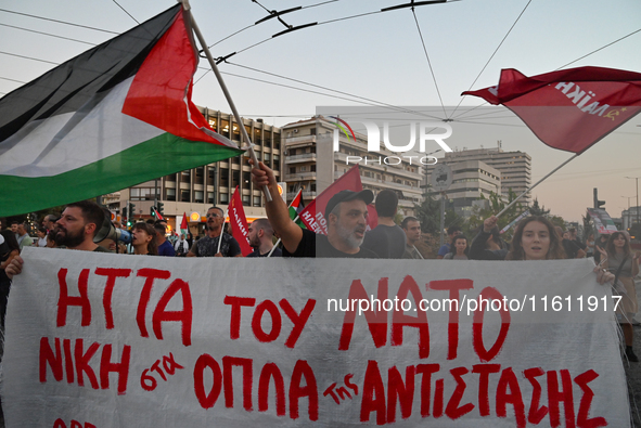 Demonstrators hold a banner and wave flags outside the Israeli Embassy protesting against the Israeli strikes in Lebanon and the ongoing war...