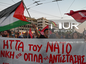 Demonstrators hold a banner and wave flags outside the Israeli Embassy protesting against the Israeli strikes in Lebanon and the ongoing war...