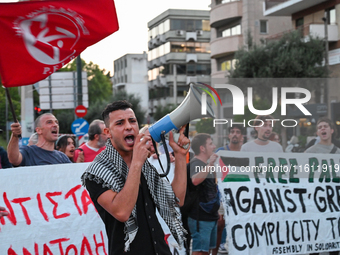 Demonstrators hold banners and flags outside the Israeli Embassy protesting against the Israeli strikes in Lebanon and the ongoing war in Ga...