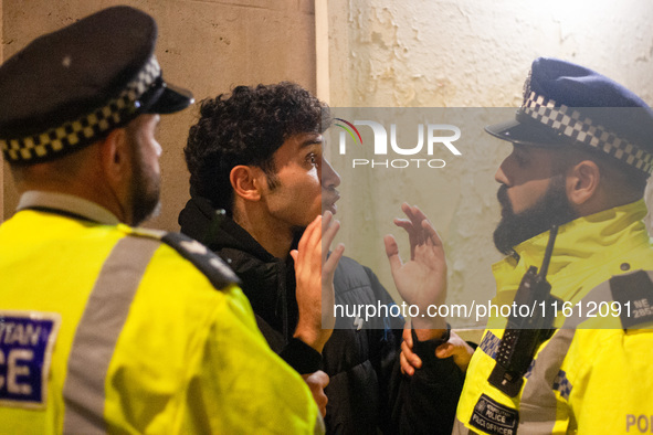 A protester is arrested by two Metropolitan Police officers during the Lebanon Ceasefire Protest at 10 Downing Street in London, England, on...