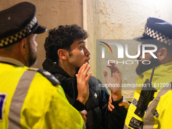 A protester is arrested by two Metropolitan Police officers during the Lebanon Ceasefire Protest at 10 Downing Street in London, England, on...