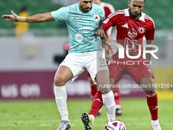 Mahmoud Hassan (L) of Al Rayyan SC battles for the ball with Ahmed Fathi Abdoulla (R) of Al Arabi SC during the Ooredoo Qatar Stars League 2...