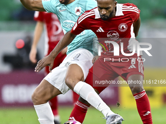 Mahmoud Hassan (L) of Al Rayyan SC battles for the ball with Ahmed Fathi Abdoulla (R) of Al Arabi SC during the Ooredoo Qatar Stars League 2...