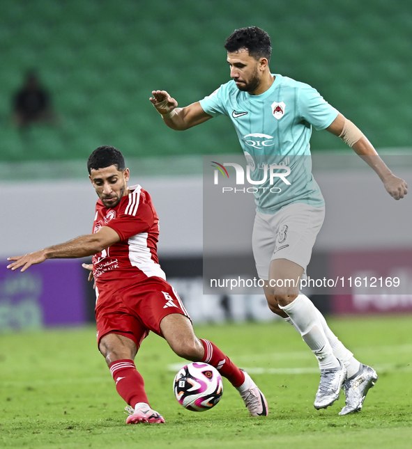 Mahmoud Hassan (R) of Al Rayyan SC battles for the ball with Abdulla Hassan Al-Marafi (L) of Al Arabi SC during the Ooredoo Qatar Stars Leag...