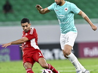 Mahmoud Hassan (R) of Al Rayyan SC battles for the ball with Abdulla Hassan Al-Marafi (L) of Al Arabi SC during the Ooredoo Qatar Stars Leag...