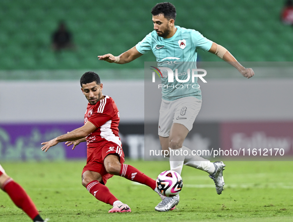 Mahmoud Hassan (R) of Al Rayyan SC battles for the ball with Abdulla Hassan Al-Marafi (L) of Al Arabi SC during the Ooredoo Qatar Stars Leag...