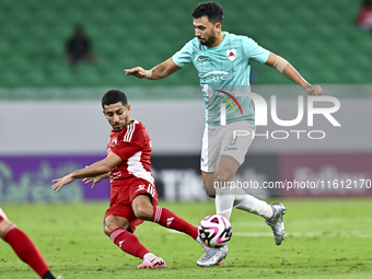 Mahmoud Hassan (R) of Al Rayyan SC battles for the ball with Abdulla Hassan Al-Marafi (L) of Al Arabi SC during the Ooredoo Qatar Stars Leag...