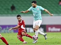 Mahmoud Hassan (R) of Al Rayyan SC battles for the ball with Abdulla Hassan Al-Marafi (L) of Al Arabi SC during the Ooredoo Qatar Stars Leag...