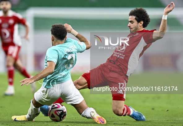 Hazem Ahmed Shehata (L) of Al Rayyan SC battles for the ball with Ahmed Alaaeildin Abdelmotaal (R) of Al Arabi SC during the Ooredoo Qatar S...