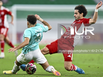 Hazem Ahmed Shehata (L) of Al Rayyan SC battles for the ball with Ahmed Alaaeildin Abdelmotaal (R) of Al Arabi SC during the Ooredoo Qatar S...