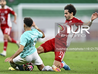 Hazem Ahmed Shehata (L) of Al Rayyan SC battles for the ball with Ahmed Alaaeildin Abdelmotaal (R) of Al Arabi SC during the Ooredoo Qatar S...