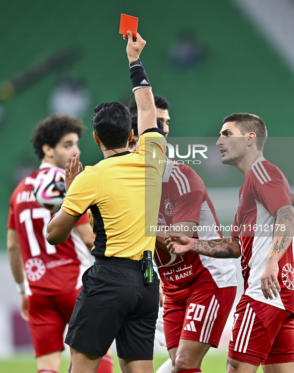 Qatari referee Abdulla Ali Athba gives a red card to Ahmed Alaaeildin Abdelmotaal (L) of Al Arabi SC during the Ooredoo Qatar Stars League 2...