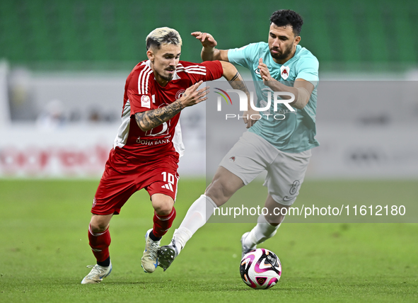 Mahmoud Hassan (R) of Al Rayyan SC battles for the ball with Rodriguez Sanchez Rodrigo (L) of Al Arabi SC during the Ooredoo Qatar Stars Lea...