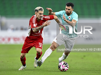 Mahmoud Hassan (R) of Al Rayyan SC battles for the ball with Rodriguez Sanchez Rodrigo (L) of Al Arabi SC during the Ooredoo Qatar Stars Lea...