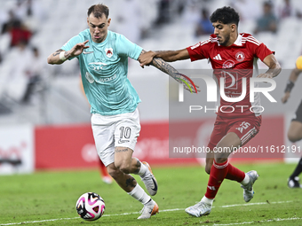 Roger Krug Guedes (L) of Al Rayyan SC battles for the ball with Jassem Gaber Abdulsallam (R) of Al Arabi SC during the Ooredoo Qatar Stars L...